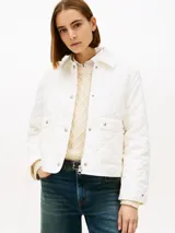 Campera acolchada Tommy Hilfiger de color blanco, confeccionada en poliéster reciclado con diseño matelasse en rombos. Presenta cuello camisero, cierre frontal con cremallera y botones a presión, dos bolsillos frontales de parche con solapa y detalle de logo bordado en el puño.