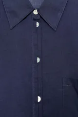 Camisa de corte amplio confeccionada en algodón, con cuello solapa, manga larga, bolsillo delantero de plastrón y cierre frontal con botones.