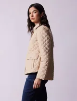 Campera capitoneada color beige, marca Weatherproof, con cuello con solapa, abertura central con botones metálicos, bolsillos delanteros y forro interno a tono.