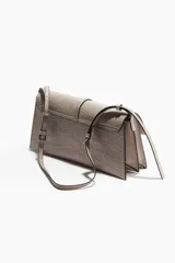 Cartera bandolera de diseño rectangular con textura de cocodrilo y solapa frontal con cierre magnético. Incluye una tira decorativa vertical con hebilla metálica y correa ajustable para el hombro.
