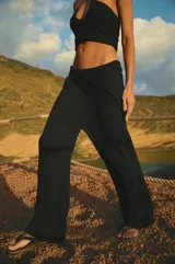 Pantalón tejido en algodón color negro, con cintura ancha en rib con elástico interno y tiras regulables. Diseño moderno y fluido.