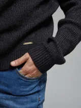 Sweater tejido color beige, de tejido grueso con textura, cuello a la base y manga larga.