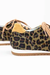 Zapatillas de estilo running con estampado animal print de leopardo. Presentan detalles en color ocre en la lengüeta, cordones, collarín y talón. Cuentan con una suela de goma dentada, entresuela blanca y una cuña interna oculta para mayor comodidad.