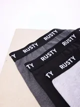 Pack de tres boxers Rusty, confeccionados en tonos gris oscuro, negro y gris claro con cintura elástica negra y logotipo de la marca estampado en contraste.