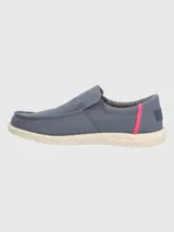 Alpargata slip-on Hush Puppies modelo Gordon, color azul grisáceo con detalle de costura lateral en color fucsia. Presenta suela de EVA moteada en tono crema y forro interior a rayas.