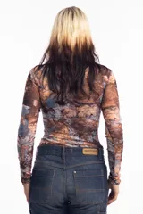 Remera de mangas largas con cuello alto y estampado abstracto en tonos marrones, celestes y grises.