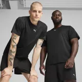 Remera deportiva Puma color negro melange con cuello redondo y el logo de la marca estampado en blanco en el pecho.