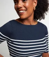Blusa de punto con textura acanalada, diseño de rayas horizontales en azul marino y blanco, escote barco y manga corta.