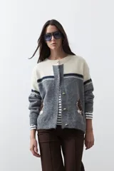 Cardigan de tejido jacquard en color azul marino y blanco, con diseño de conejitos en los laterales, cierre frontal con botones y cuello redondo.