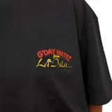 Remera negra de manga corta con cuello redondo y estampado frontal en el pecho que dice "G'DAY MATE! from La Isla..." en colores rojo y amarillo.