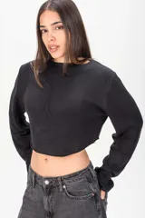 Sweater crop negro de punto con diseño abierto y tiras deshilachadas en la espalda, de manga larga.