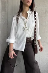 Camisa blanca de manga larga con detalles bordados en el canesú y cuello clásico.