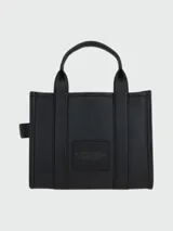 Bolso tote pequeño de cuero texturizado color gris con doble asa corta superior y correa larga extraíble y ajustable para llevar al hombro. Estampado frontal con el texto "The Tote Bag" y el nombre de la marca.