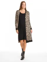 Vestido midi de tejido de punto con diseño integrado que simula un conjunto de vestido negro liso con un cárdigan largo estampado de eslabones geométricos en blanco y negro. Presenta escote redondo y mangas largas.