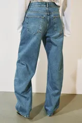Jeans de tiro medio confeccionados en denim con efecto lavado, diseño de pernera curva y corte recto. Cuenta con cinco bolsillos, trabillas en la cintura y cierre frontal con cremallera y botón metálico.