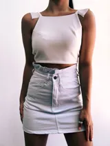Crop top negro con textura brillante, breteles anchos con volados y espalda descubierta que se ata con lazos.