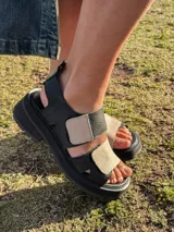 Sandalias de cuero negras con plataforma y tiras anchas ajustables en color beige.