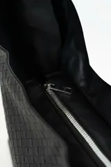 Cartera tipo hobo de cuero sintético bordó, con diseño trenzado y asa integrada.