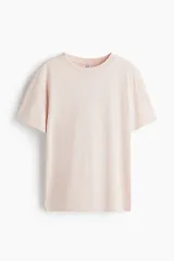 Remera rosa pálido de corte holgado, con cuello redondo y mangas cortas. Confeccionada en tejido de punto suave.