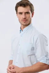 Camisa lisa de manga larga de algodón en color gris claro, de corte slim fit con cuello camisero y cierre frontal de botones.