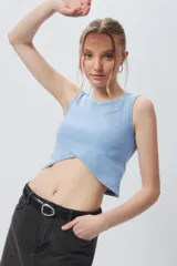 Musculosa corta negra sin mangas, de corte asimétrico frontal y ceñida al cuerpo.