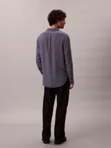 Camisa de manga larga Calvin Klein con estampado de rayas verticales finas, cuello camisero y cierre frontal con botones.