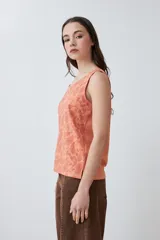 Musculosa de calce holgado en color durazno, con estampado paisley en relieve (puff print) en tonos rojizos. Presenta cuello redondo y diseño sin mangas.