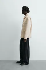 Sobrecamisa relaxed fit color beige, confeccionada en tejido de algodón. Cuenta con cuello solapa, manga larga con puño abotonado, bolsillos plastrón en el delantero y cierre frontal de botonadura.