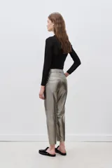 Pantalon de corte recto confeccionado en cuero ovino con acabado metalizado en color plata. Presenta cierre frontal con cremallera y bolsillos laterales.