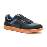 Sneaker Caterpillar modelo Pause Retro, de diseño urbano con combinación de cuero napa y gamuza en color negro. Presenta detalles en azul en los laterales y el interior, con una suela de goma color naranja con textura hexagonal y logo grabado.