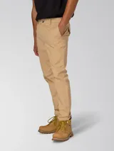 Pantalón chino beige de corte slim tapered, con bolsillos laterales y traseros, cierre de cremallera y botón, y tejido elástico.