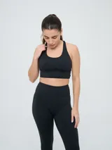 Top deportivo Umbro color negro con diseño de espalda nadadora y banda elástica en la base para mayor soporte.