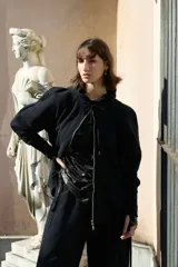 Campera deportiva oversize color bordó con capucha, cierre metálico frontal y mangas raglán de volumen pronunciado. Cuenta con puños largos de rib elástico y cordones regulables a tono con terminaciones metálicas.