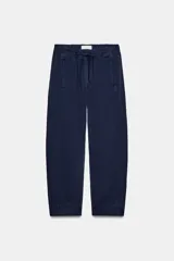 Pantalón de tiro bajo con cintura elástica ajustable mediante cordón, bolsillos delanteros y bolsillos de plastrón en la parte trasera.