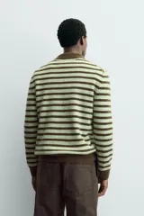 Polo de punto de manga larga con diseño de rayas horizontales en tonos verde y marrón. Presenta cuello solapa, cierre frontal con botonadura y acabados en rib en puños y ruedo.