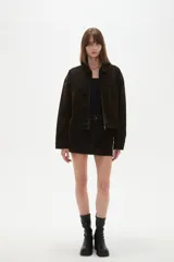 Campera de jean color marrón oscuro, con cierre frontal, cuello clásico y bolsillo frontal tipo parche.