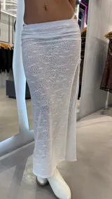 Pollera larga blanca de encaje con tajo lateral y tiro bajo.