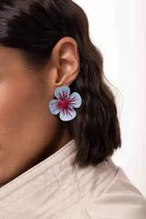 Aro con forma de flor pintada a mano, con pétalos en tono celeste y detalles de trazos en color bordó con brillo. El centro de la flor está decorado con mostacillas fucsias.