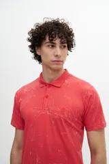 Chomba color coral con estampado de hojas blancas, cuello clásico con cartera de dos botones y logo bordado en el pecho.