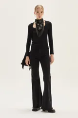 Top negro de manga larga, confeccionado en tela de lurex con calce al cuerpo y escote cuadrado.