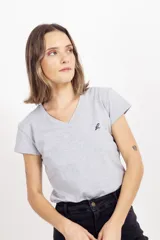 Remera de algodón gris melange con cuello en V y manga corta. Presenta un pequeño bordado en el pecho izquierdo.