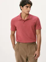 Chomba básica color rojo coral, de manga corta, con cuello polo y cierre frontal de botones.