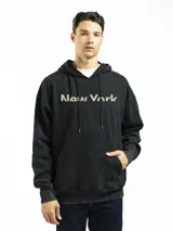 Buzo canguro negro con capucha y bolsillo frontal, con estampado de la frase 'New York' en color beige. Corte oversized y puños acanalados.