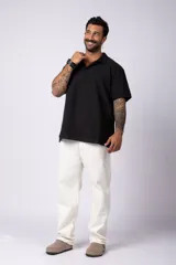 Chomba de manga corta con cuello polo, confeccionada en tejido de punto acanalado de textura pesada. Presenta un calce relajado y cuenta con una pequeña etiqueta distintiva en el ruedo.