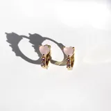 Par de aros tipo argolla dorados con bisagra, con cristales rosas en forma de corazón y pequeños cristales engarzados.