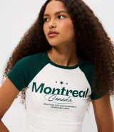 Remera de algodón con diseño tipo ringer, de corte ajustado y mangas cortas con sisa raglán en color verde oscuro. Presenta estampa frontal con lettering Montreal y detalles en color blanco.