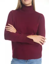 Polera de tejido fino, color rosado, con cuello alto, manga larga y detalle de tajo en los puños.