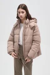 Campera puffer de corte holgado, color beige, con capucha desmontable, cierre frontal y puños elásticos.