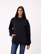 Canguro negro de corte holgado con capucha y cordones ajustables. Presenta un bolsillo frontal tipo canguro y un pequeño logo bordado en el pecho.