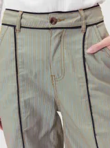 Pantalón sastrero de tiro medio, pierna ancha y corte recto, color bordó con finas rayas verticales y detalles de vivos a contratono en la pretina y el frente.